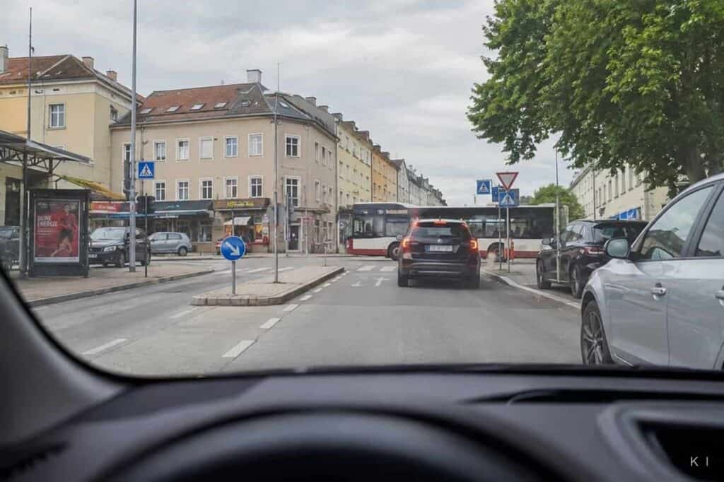 Verkehrssituation in der Stadt – Probezeit - INFAR Blick aus dem Auto auf eine innerstädtische Kreuzung im dichten Verkehr